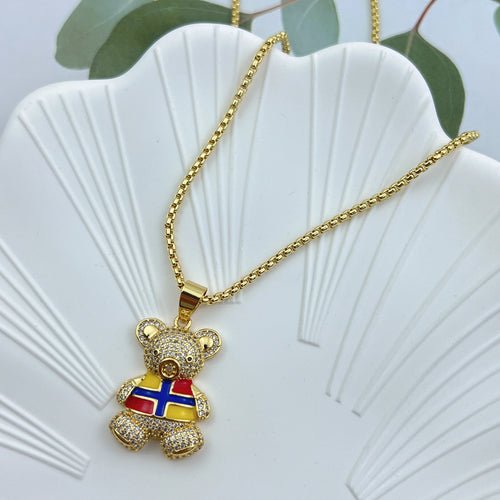 Gold chain necklace with crystal teddy bear pendant with red, blue, and yellow detail.