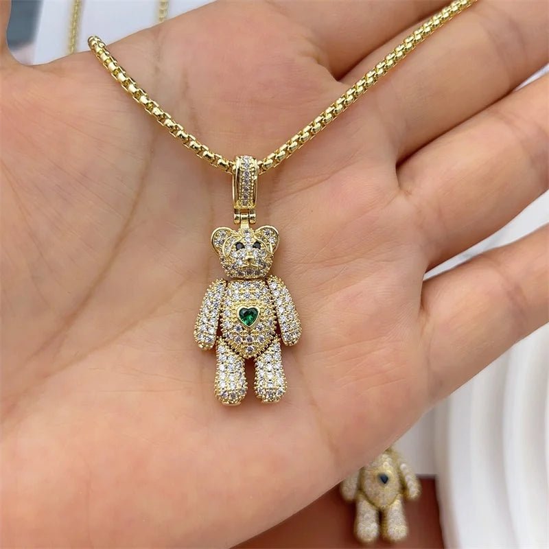 Gold teddy bear pendant necklace with crystal heart charm.