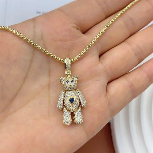 Gold teddy bear necklace with crystal details and blue heart. Charm pendant jewelry.