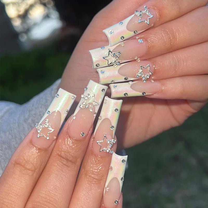Long coffin press-on nails with white tips, rhinestone accents, and 3D star charms.