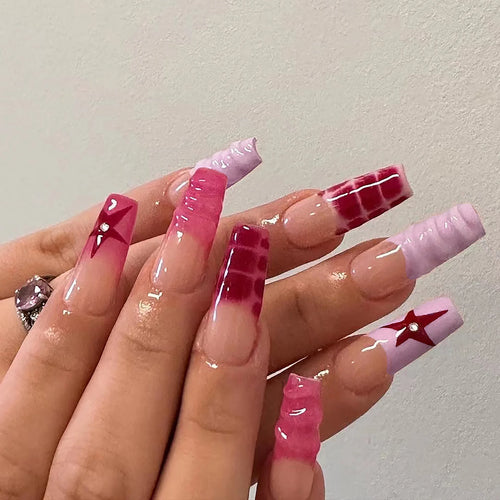 Long coffin press-on nails with pink, red, and star designs; rhinestone accents.