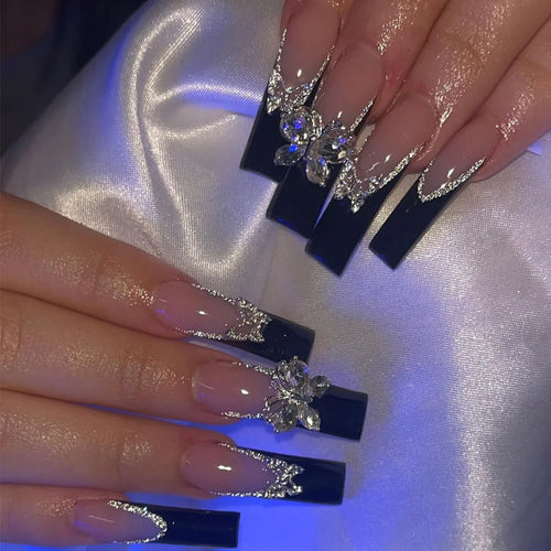 Long black coffin nails with rhinestones and French tips.
