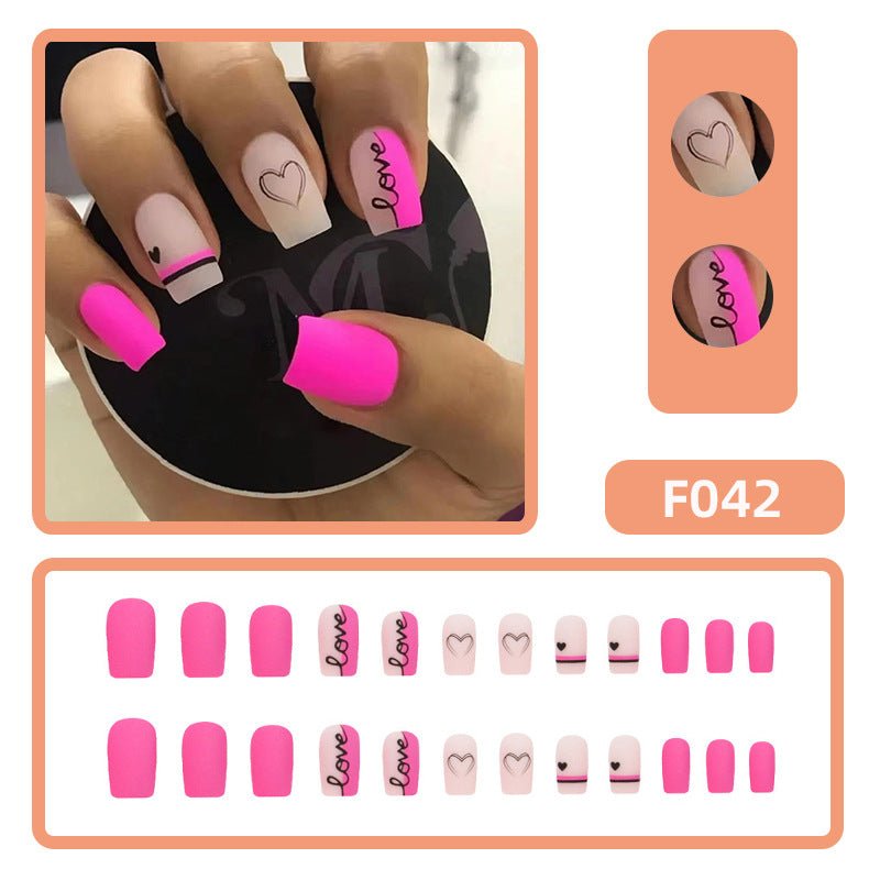Valentine's Day press-on nails, pink and white with heart and 'love' designs.