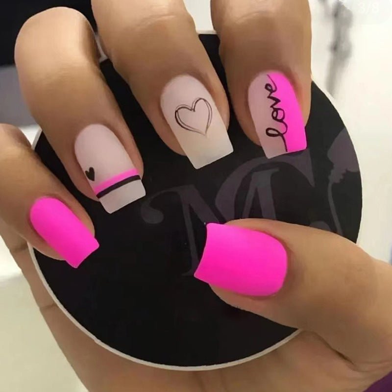 Valentine's Day press-on nails with pink, white, heart, and 'love' designs.