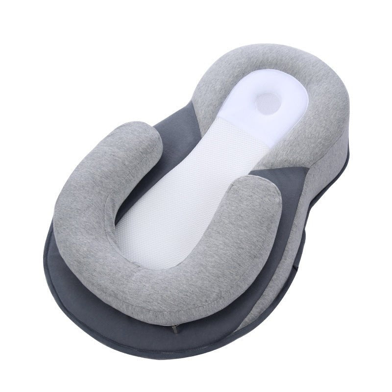 Gray newborn lounger with head support pillow. Infant sleep positioner for crib or bed.