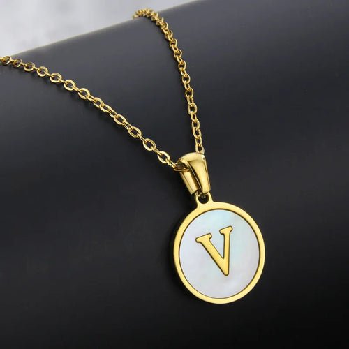Gold initial pendant necklace with letter V. Stainless steel circle pendant on a gold chain.