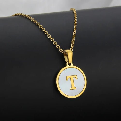 Gold stainless steel necklace with white circle pendant and a gold letter T.