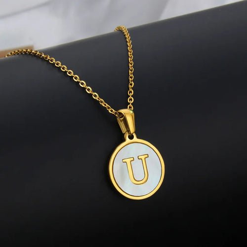 Gold initial pendant necklace featuring the letter U on a white circle.